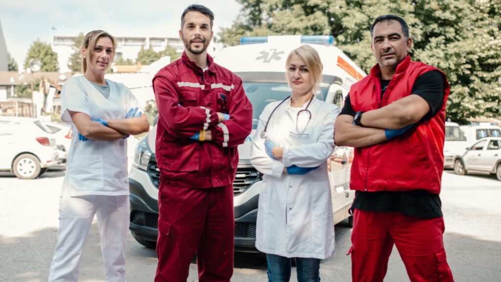 A team of emergency medical evacuation staff standing in front of an ambulance
