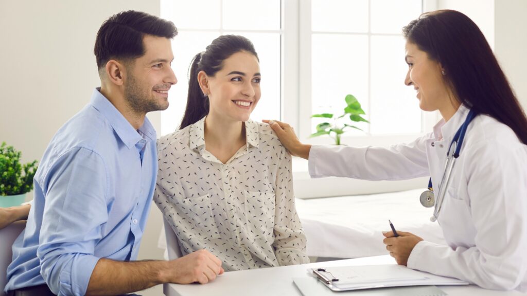 Expat couple talking with a doctor about their health coverage