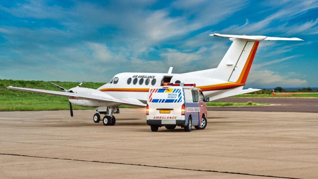 An air ambulance plane parked next to a medical rescue ambulance van on an airport tarmac.